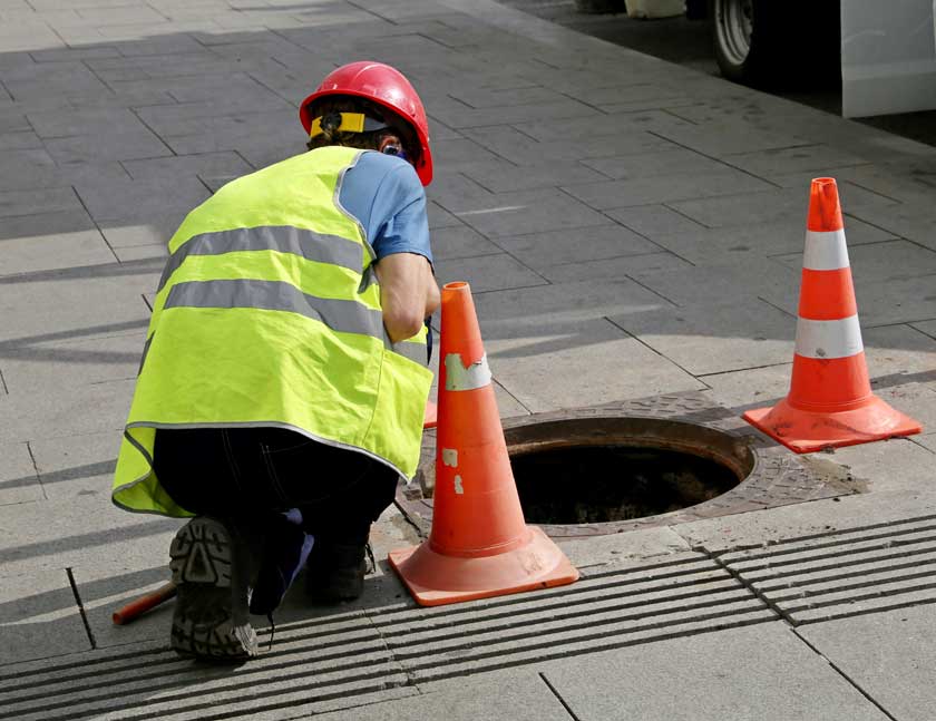Drainage Engineer Inspecting Manhole